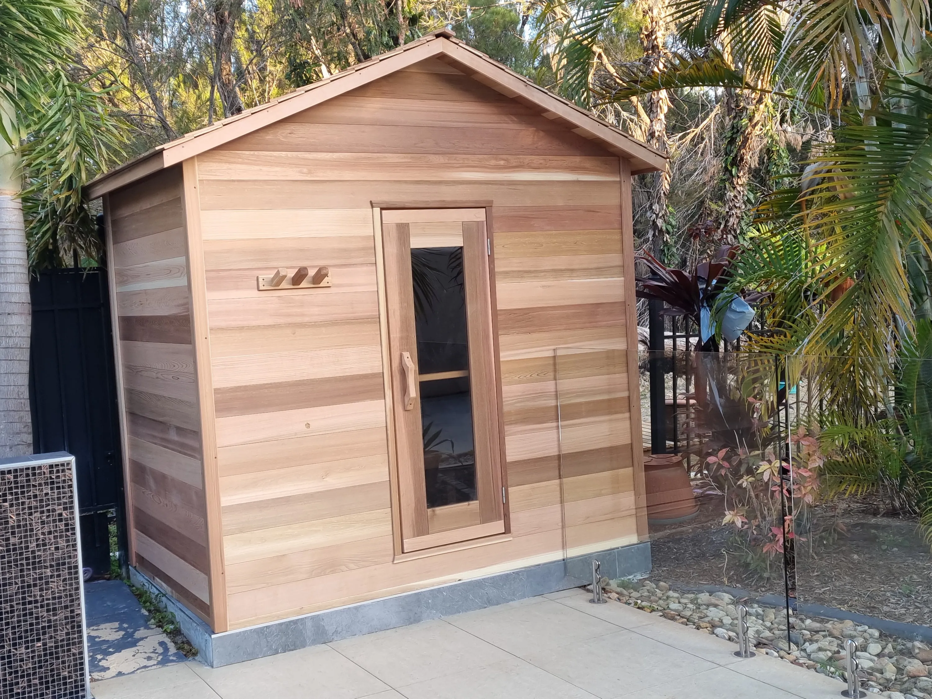 Front of the cabin sauna with a narrow glass door