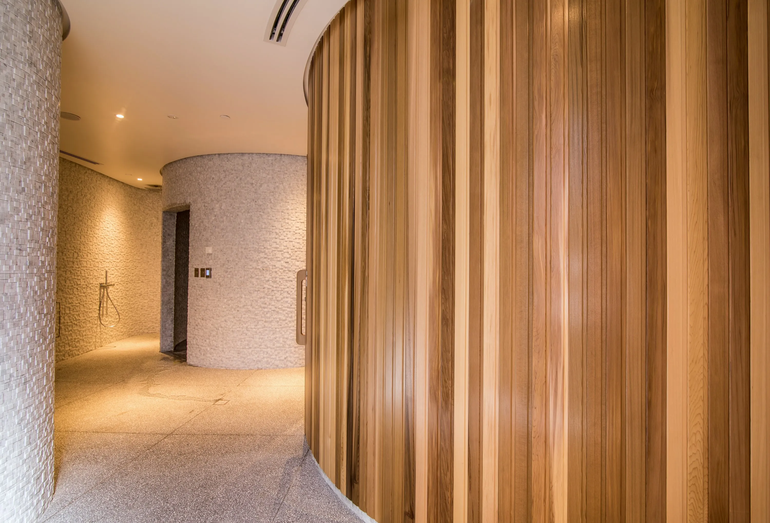Vertical cedar boards following the curve of the sauna wall
