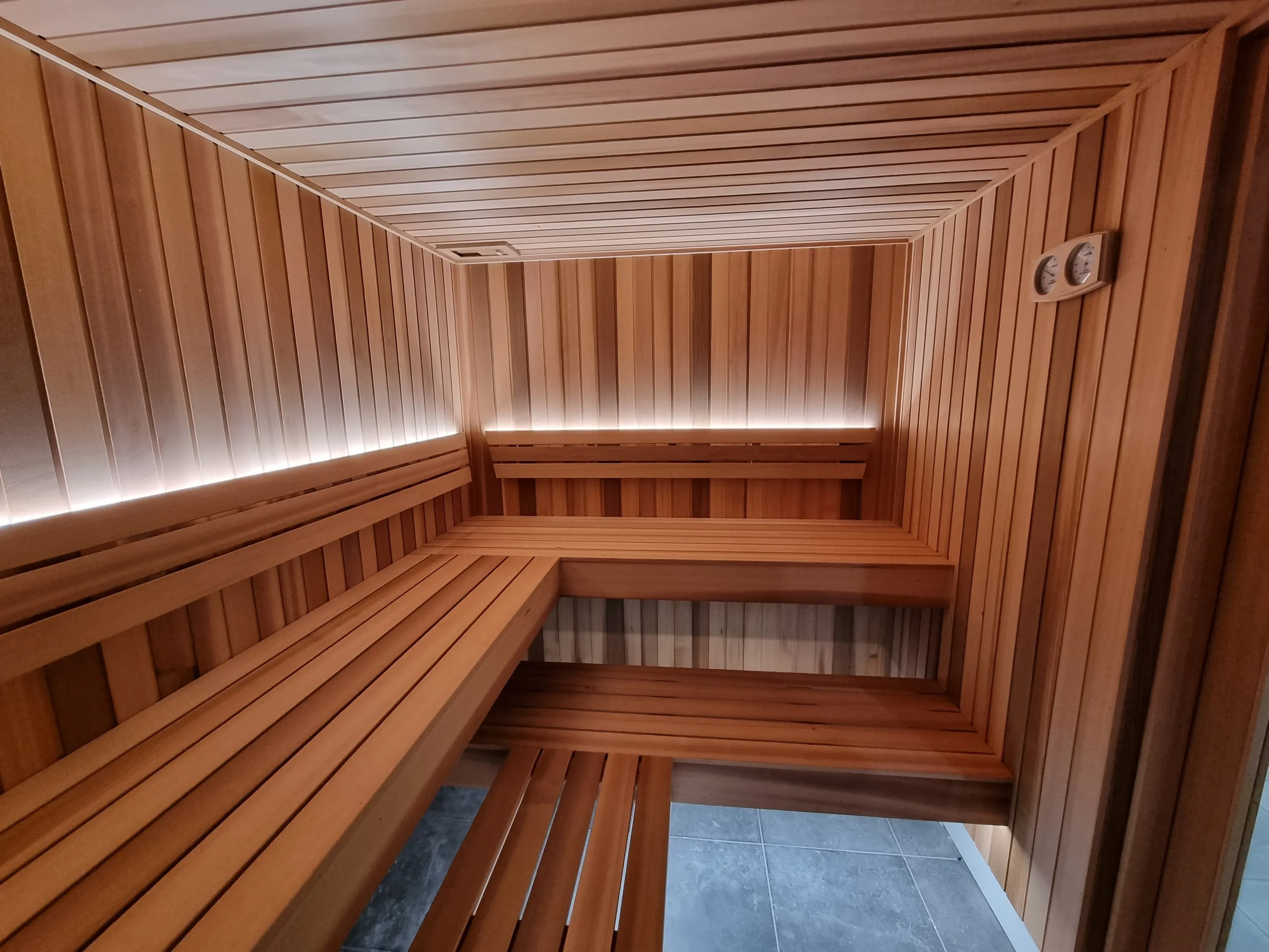Corner of tiered timber benches with lighting under the backrest