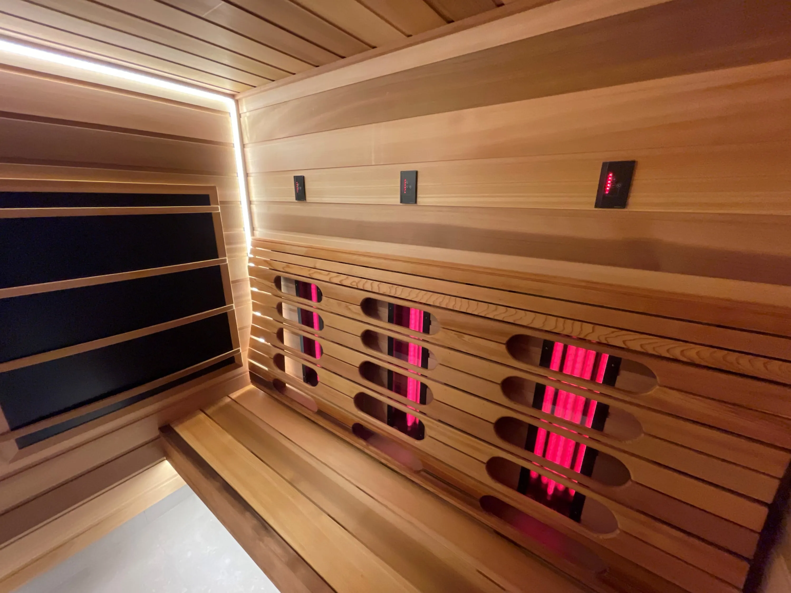 Slatted timber backrest with red infrared emitters behind it