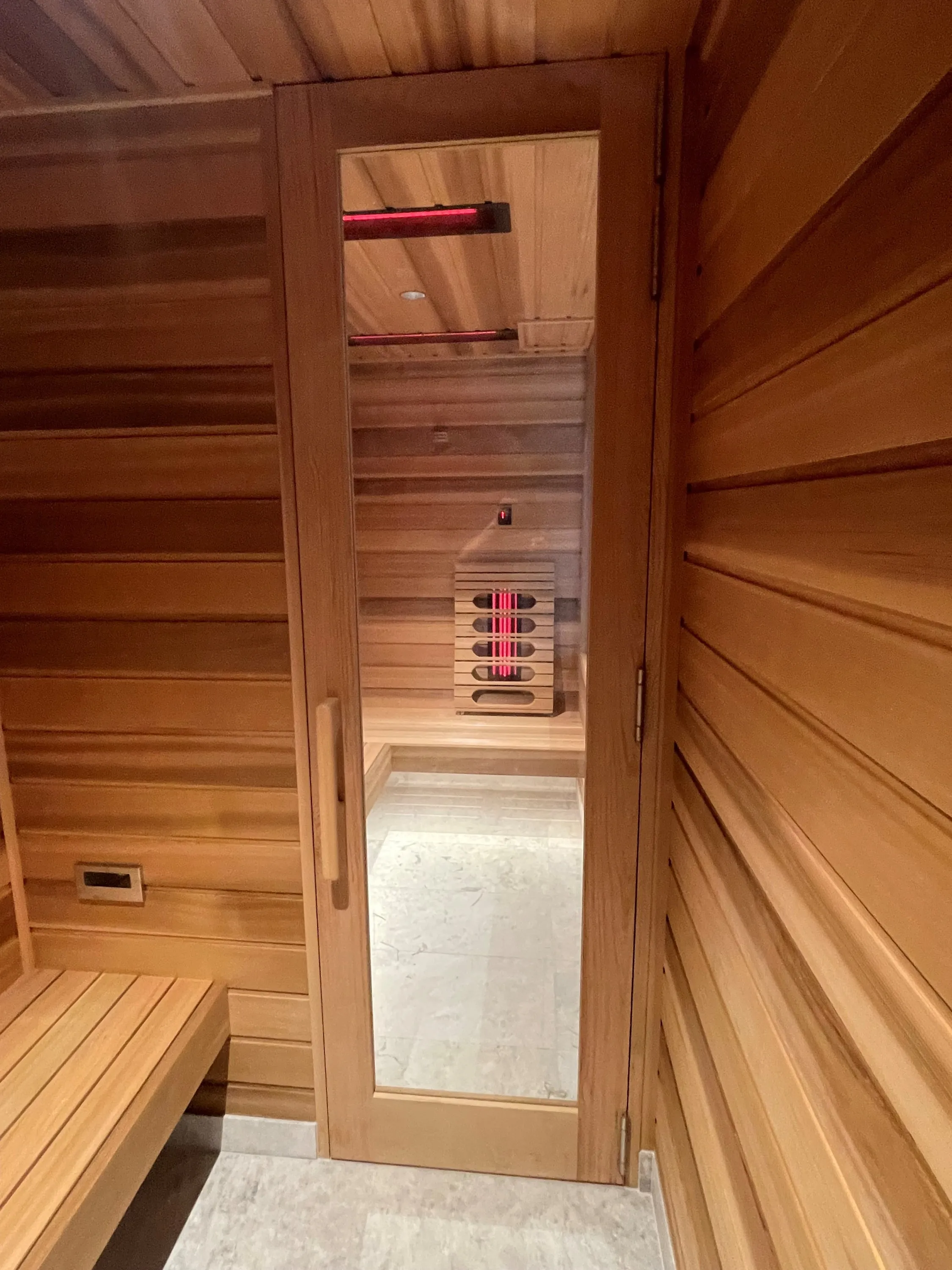 Tall glass door into a timber infrared sauna