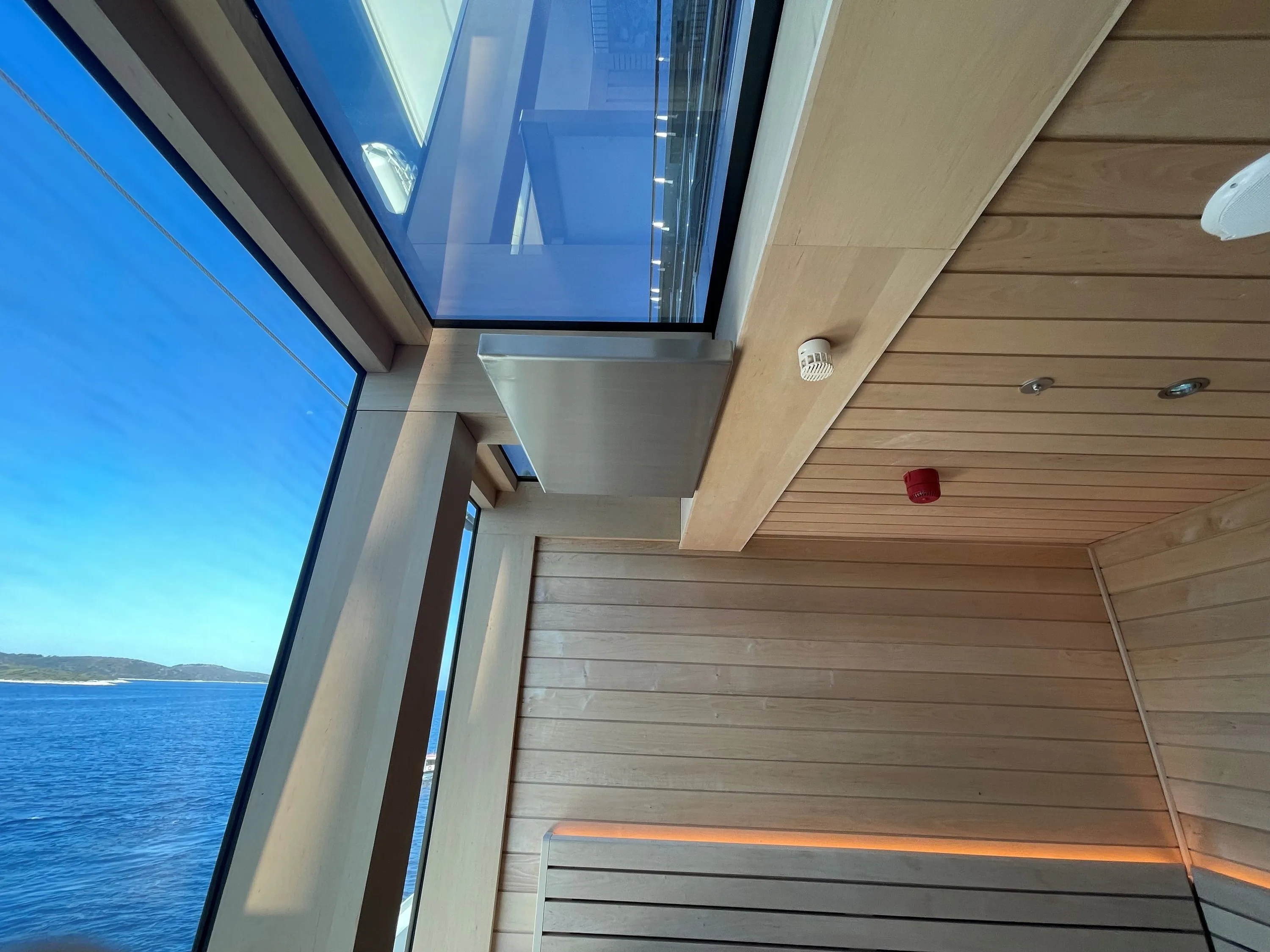 Sauna bench beside a window with the ocean beyond
