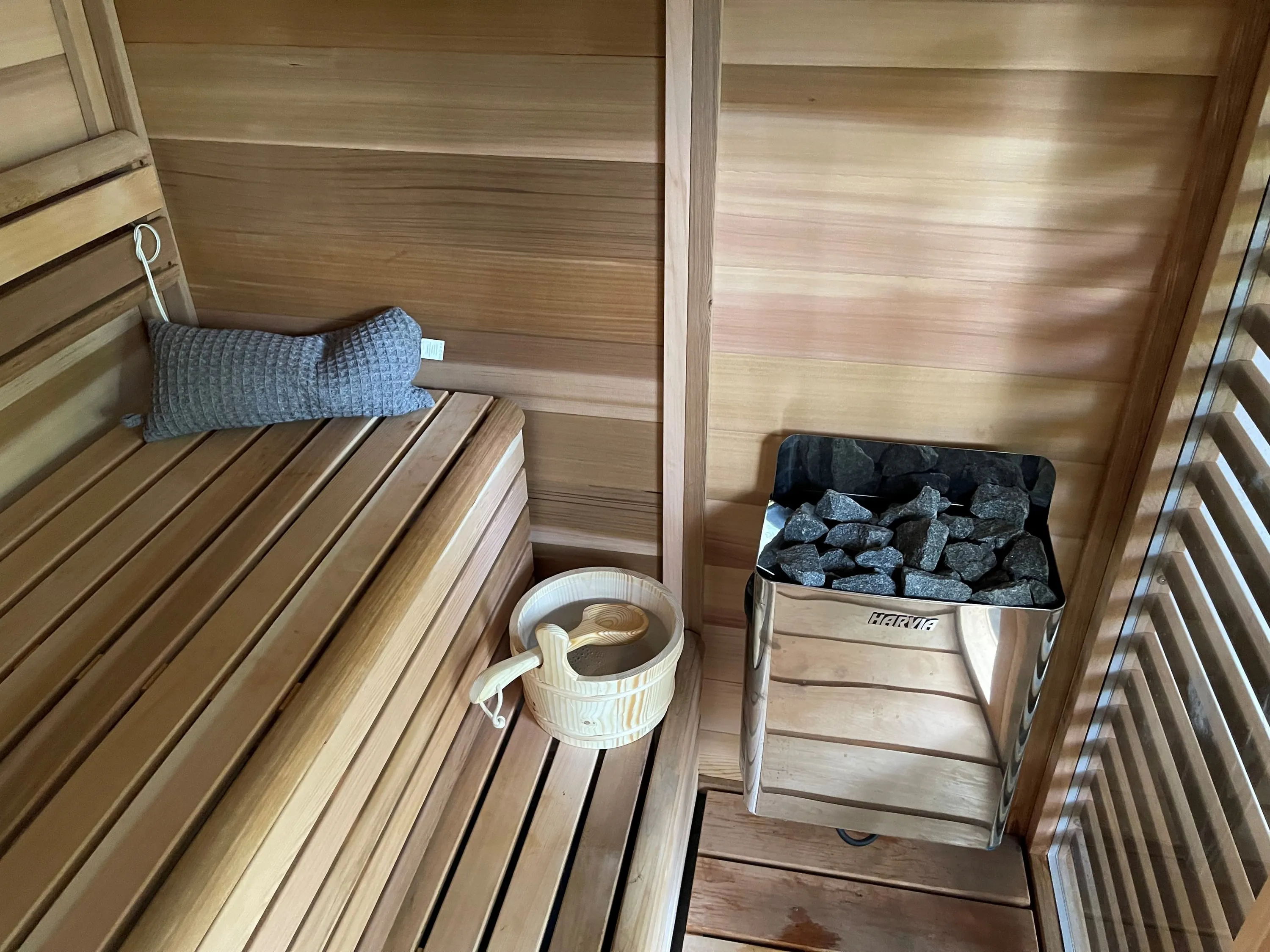 Inside the Pure Cube, cedar benches beside a heater filled with stones