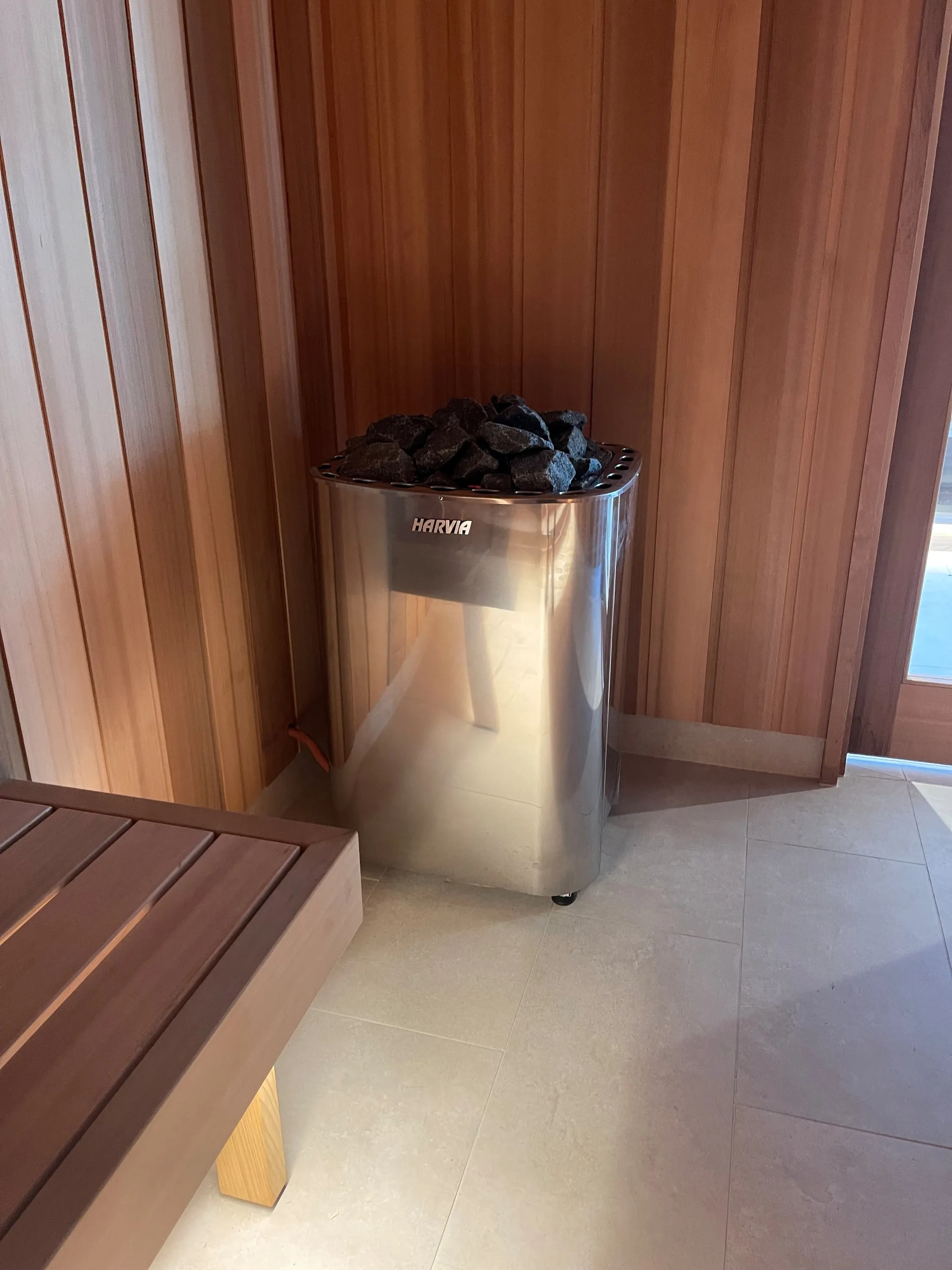 Sauna heater filled with dark, rough-cut sauna stones
