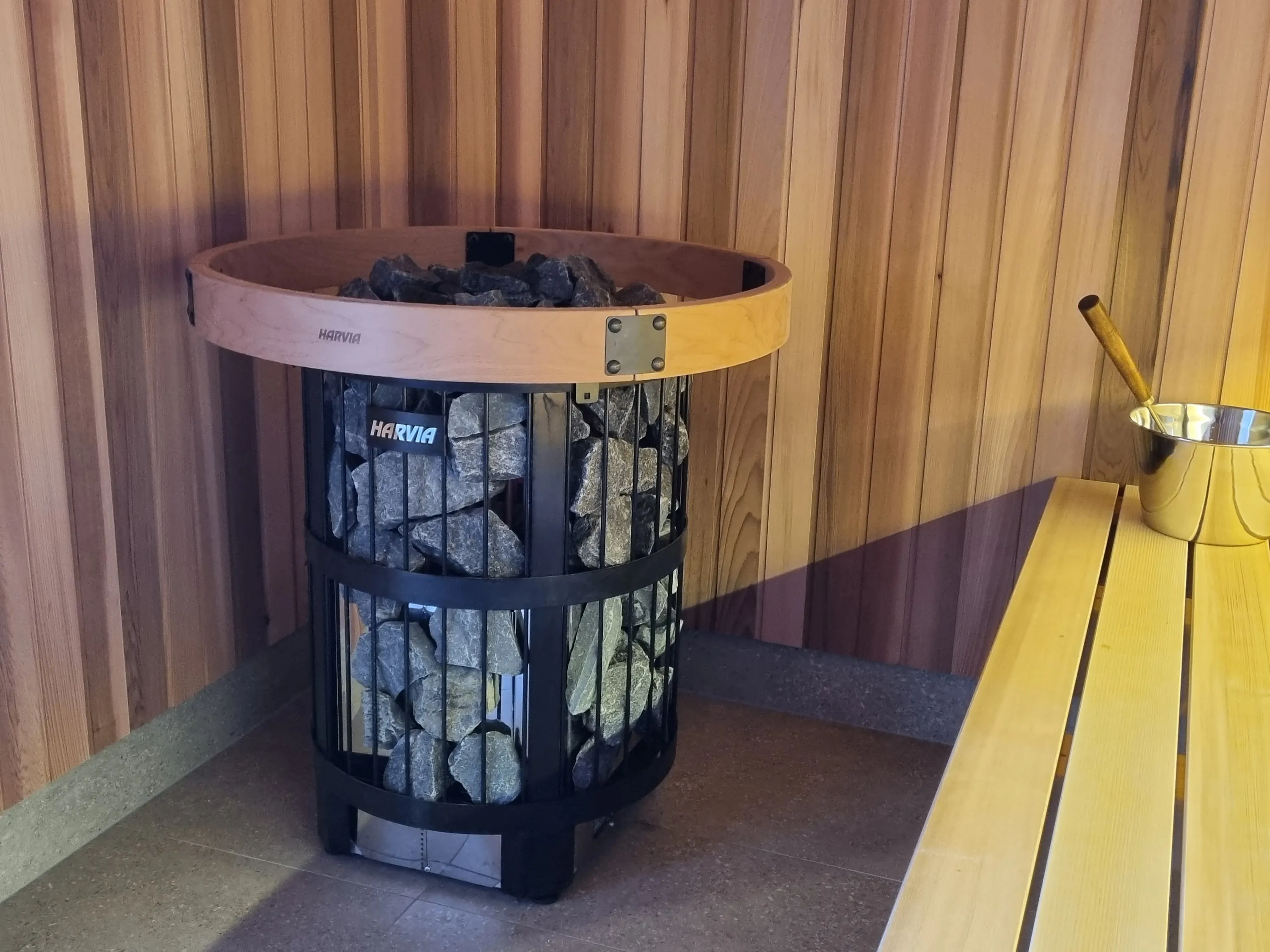 Round stone-filled tower heater with a timber top ring