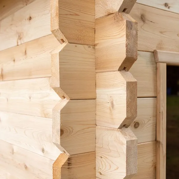Close-up of interlocking log corner joints in light knotty timber