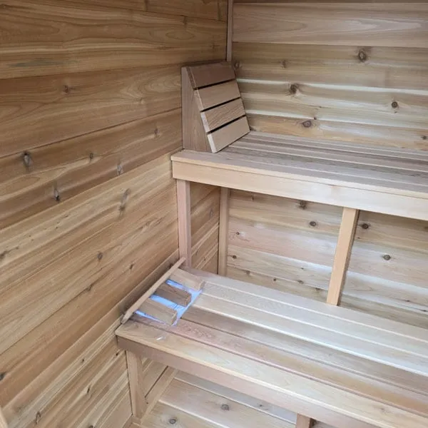 Cabin sauna interior: two-tier knotty cedar benches with headrest and corner backrest