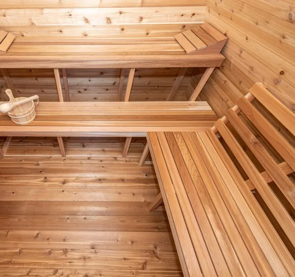 Overhead view of two-level L-shaped cedar benches in a knotty cedar sauna, bucket on the lower bench