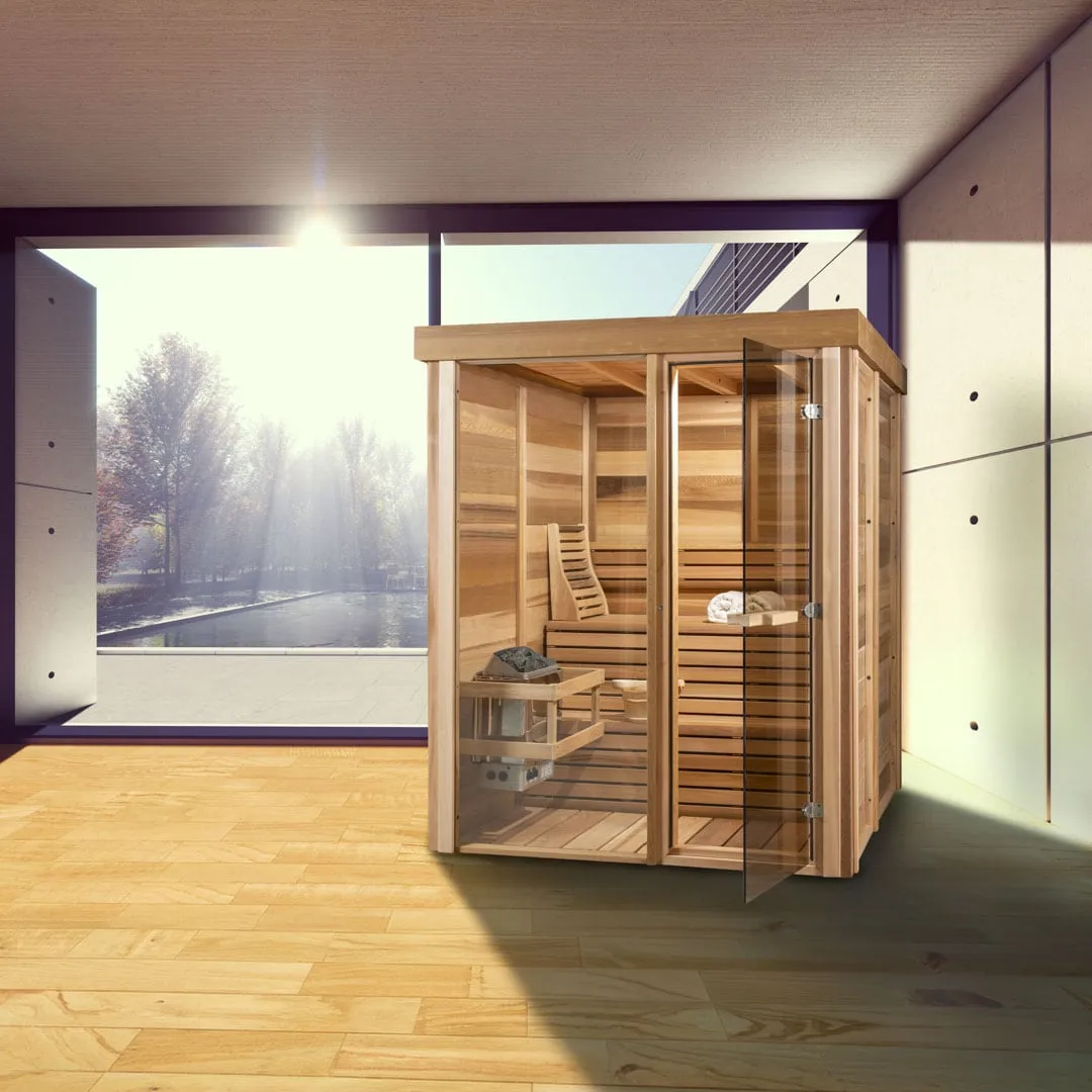 Indoor clear cedar cube sauna with glass front and open frameless glass door, heater and two-tier benches visible, in a sunlit room