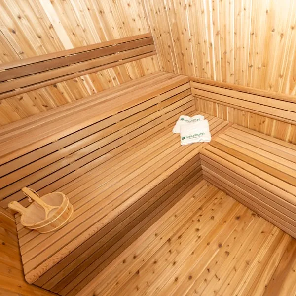 Overhead view of L-shaped cedar benches with wooden bucket and ladle and folded towels, knotty cedar walls and floor